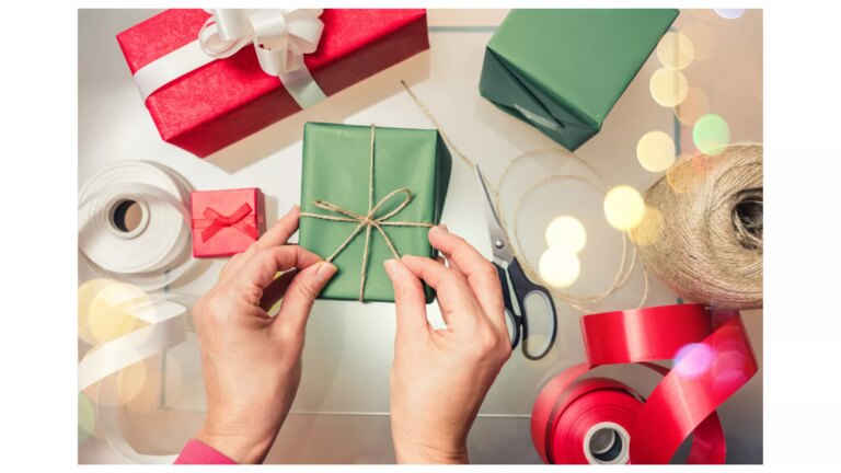 Overhead view of two hands wrapping a gift