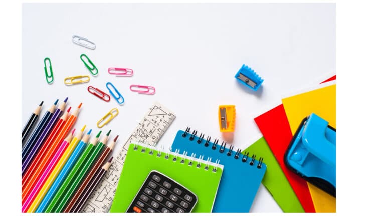 Notebooks and office supplies scattered on a white surface