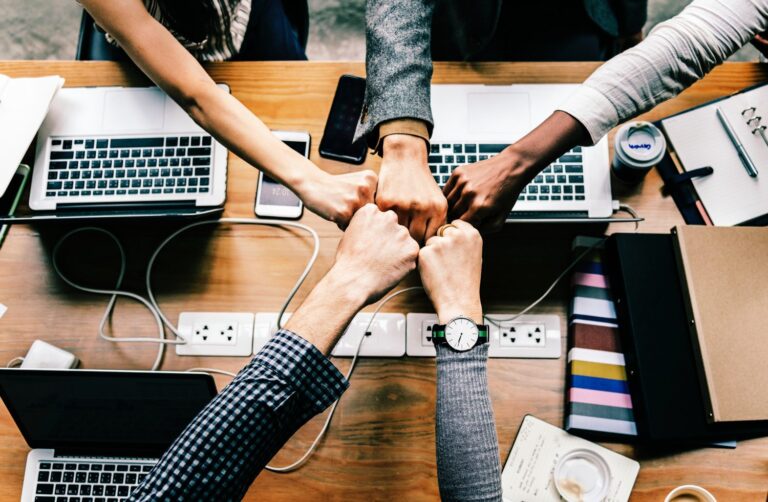 Overhead view of a five-way fist bump in an office