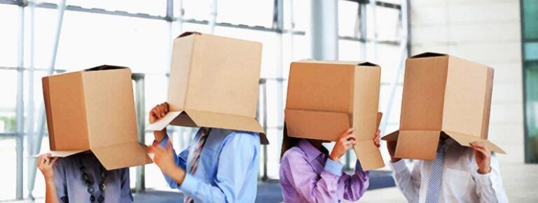 man holding a box with the words, "We're moving" written in black marker