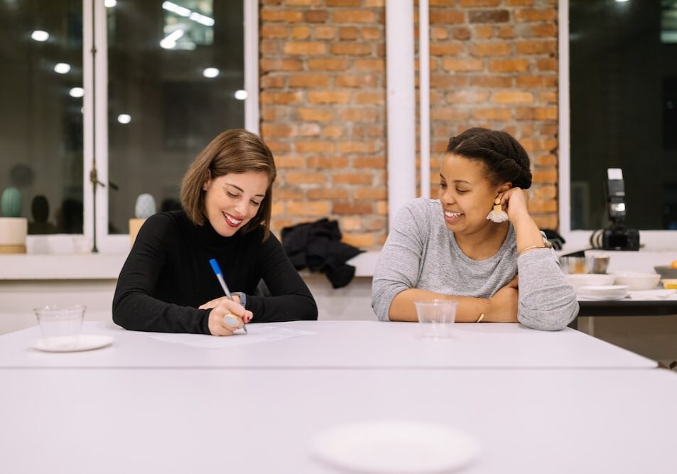 Two women working together at a large conference room table
