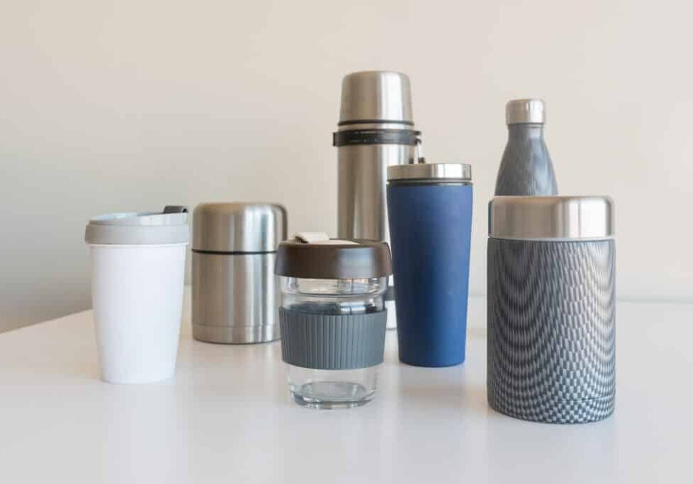 Collection of reusable food and drink containers on white table - sustainability concept (selective focus)