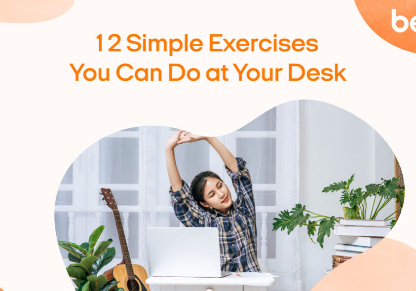 Image shows a girl stretching her arms at a white desk with the words "12 simple exercises you can do at your desk"