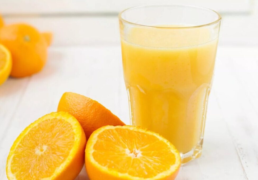 Orange halves with a glass of orange juice