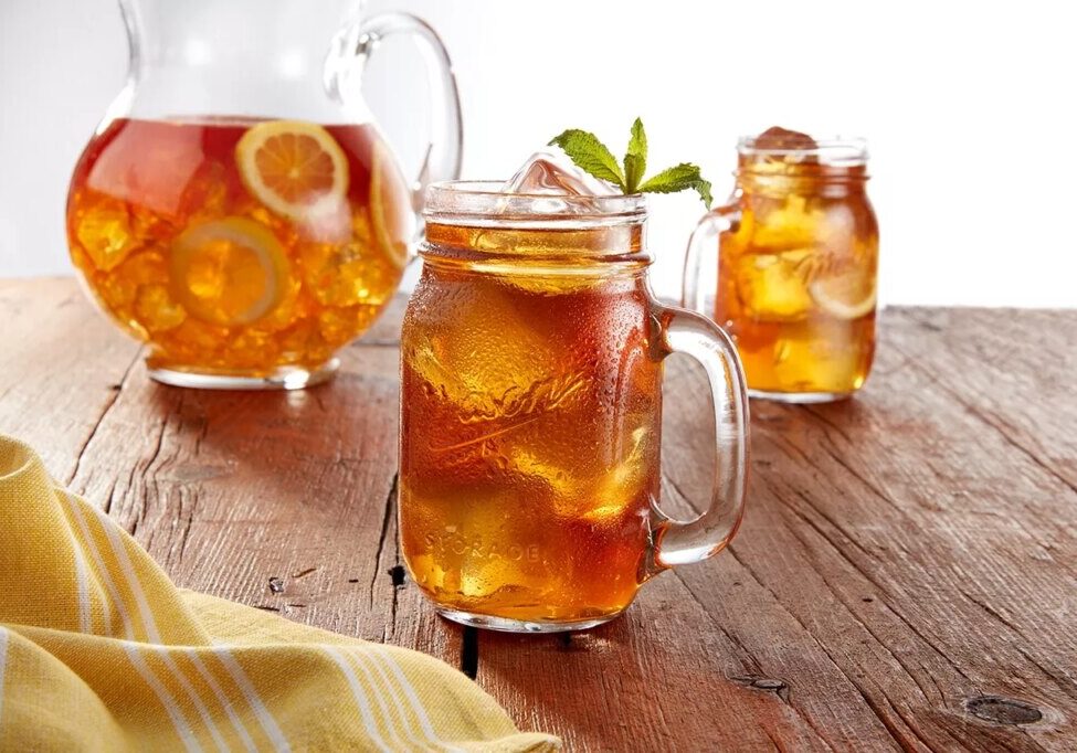 Mason jar drinking glass filled with iced tea